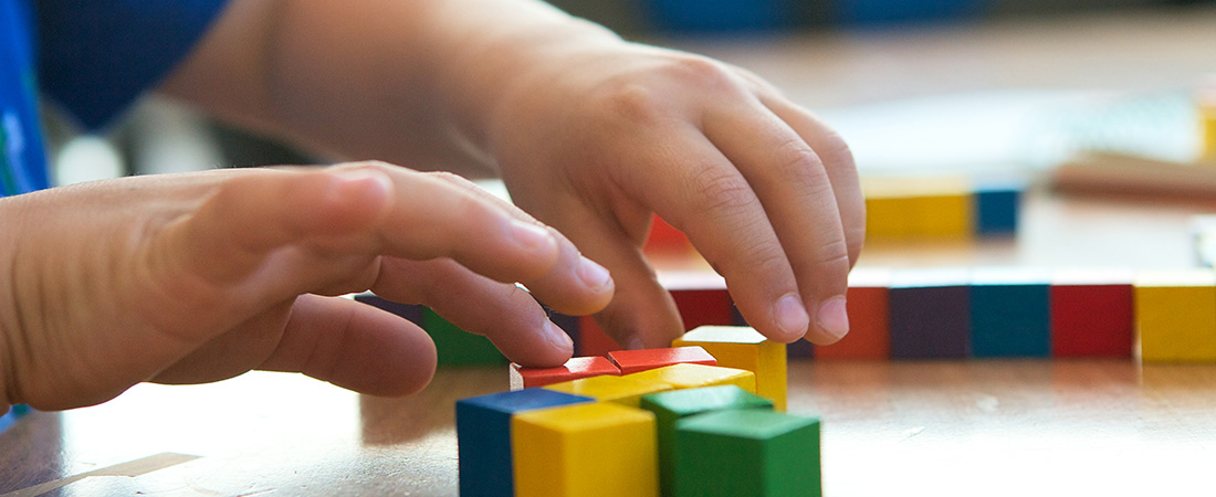 A student using blocks to solve a math problem. A student using blocks to solve a math problem.