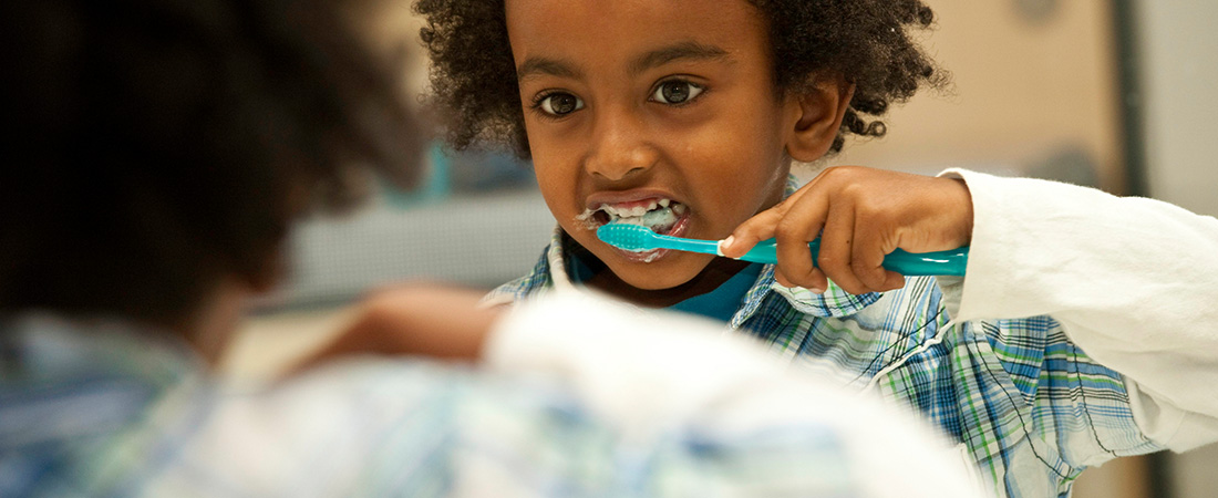 Picture of a young child brushing her teeth.