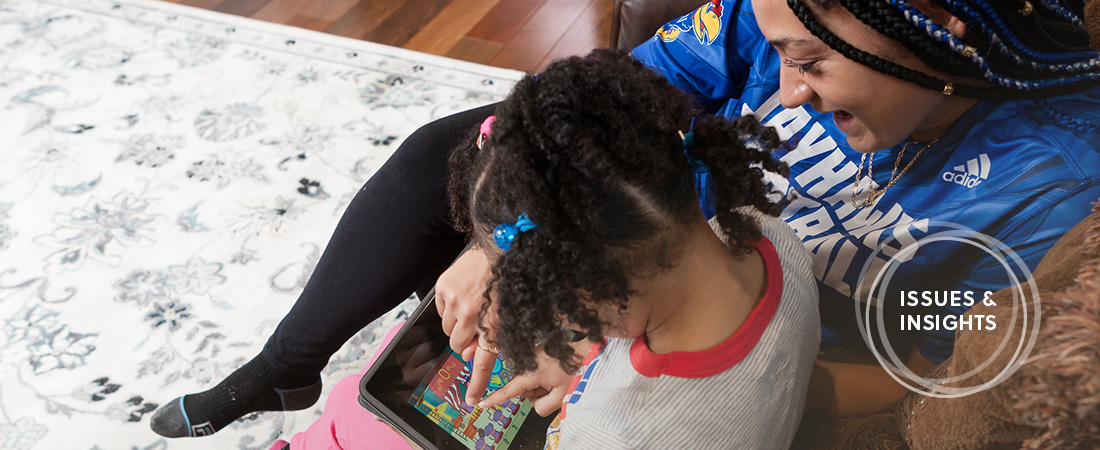 A photo of child and parent using tablet