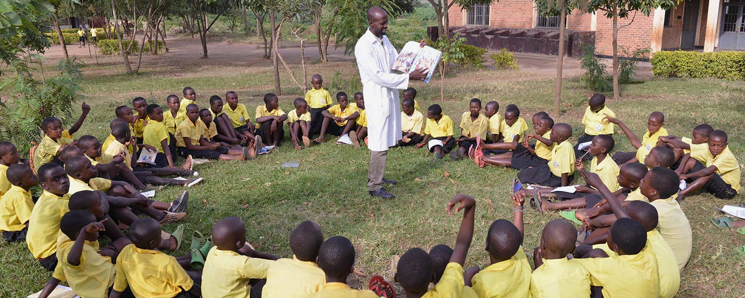 A teacher reads to students in Rwanda. A teacher reads to students in Rwanda.