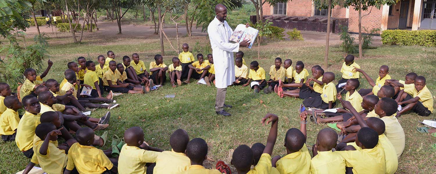 A teacher reads to students in Rwanda.