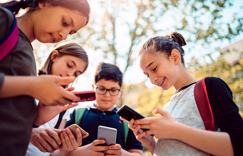 A photo of youth on phones representing Inclusion for Children with Special Needs Must Extend to Social Media