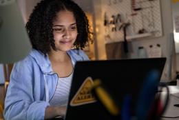 A photo of a person using a computer representing Making the Transition to Virtual Classrooms