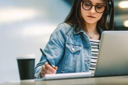 A photo of a person using a computer representing Making the Transition to Virtual Classrooms